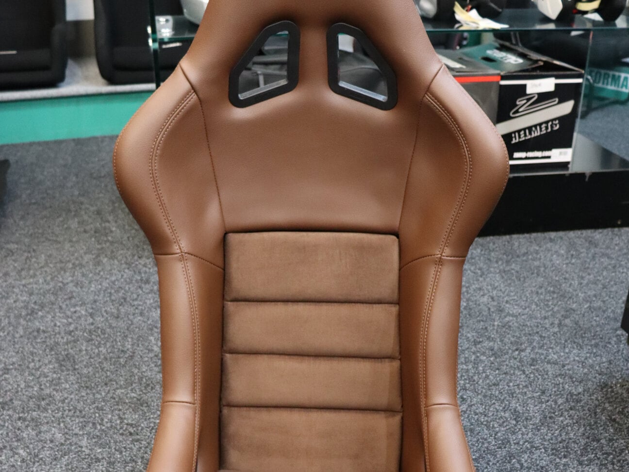 A Mirco GT Classic bucket seat in dark tan vinyl and suede on the showroom floor