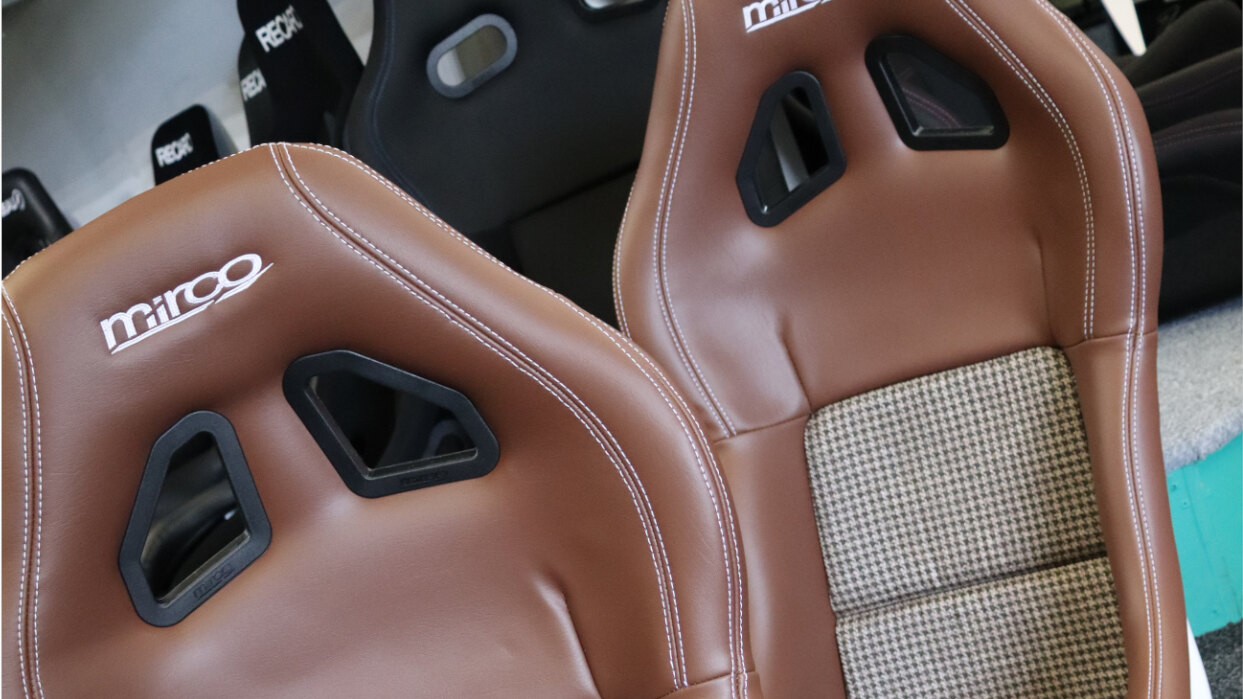 A pair of Mirco MX5 bucket seats in brown vinyl with houndstooth centre panels on the SportSeats4u showroom floor