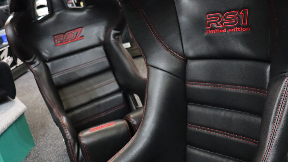 A Mirco RS1 Limited Edition and a Mirco RS7 Limited Edition bucket seat in black vinyl with red stitching in the GSM Performance showroom
