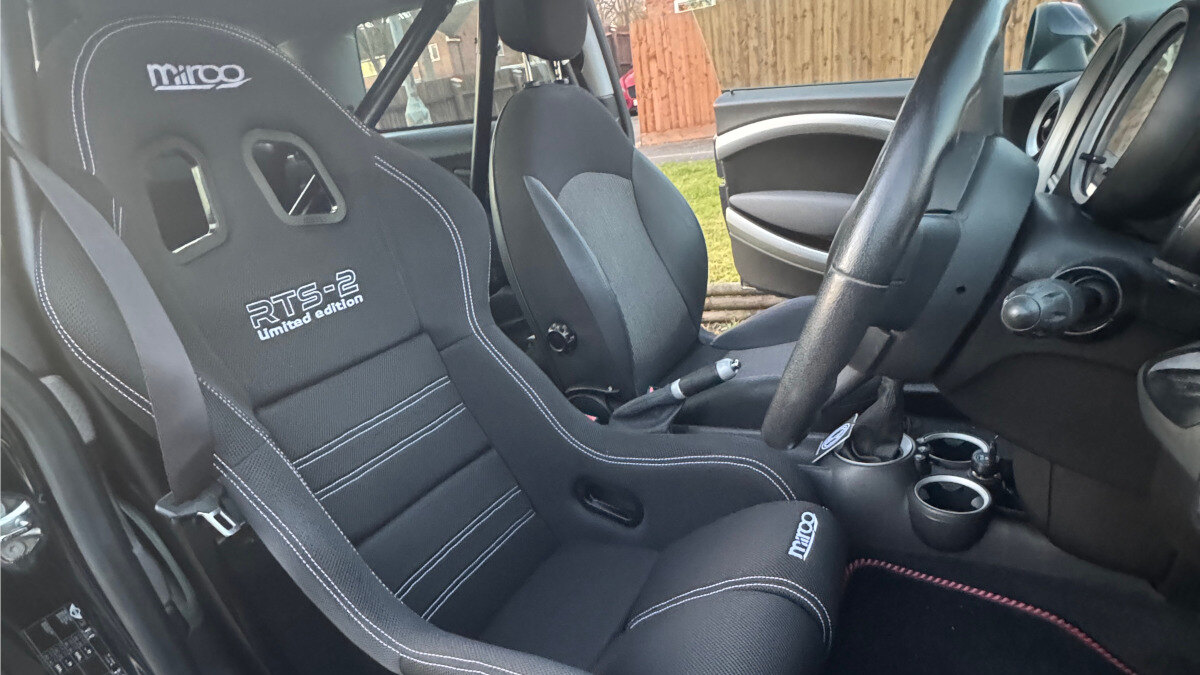 A black Mirco RTS-2 Limited Edition bucket seat fitted low in a customer's Mini Cooper S R53, seen through the open door