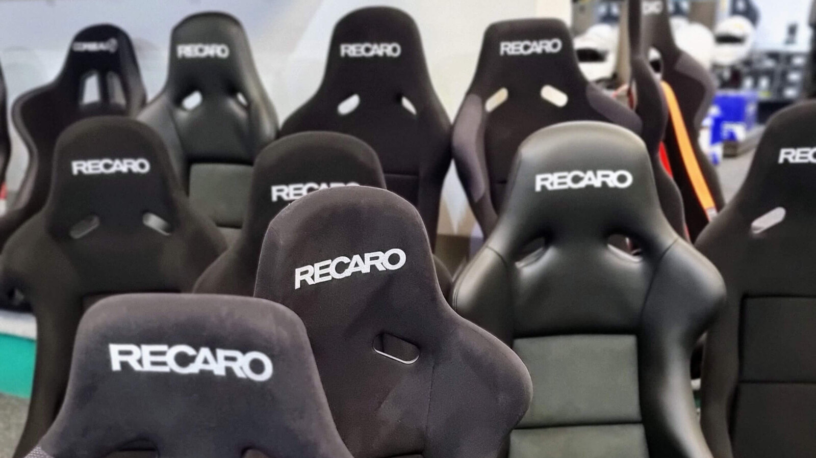 Rows of black Recaro bucket seats standing on the SportSeats4u showroom floor