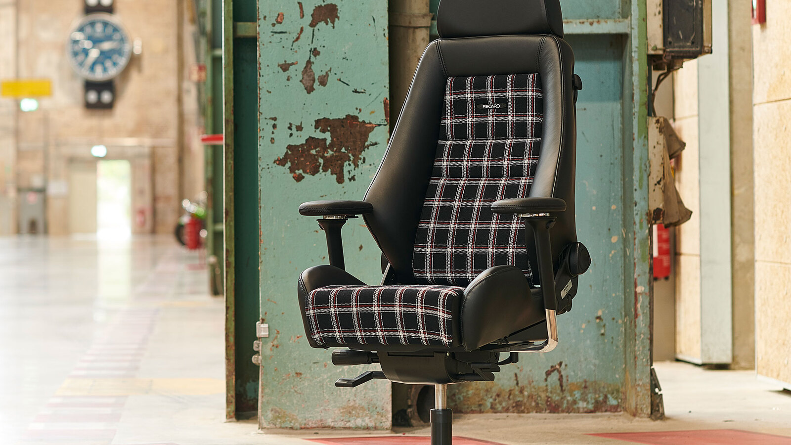 A Recaro Classic LX Star office chair with black leather and checked fabric in an industrial building
