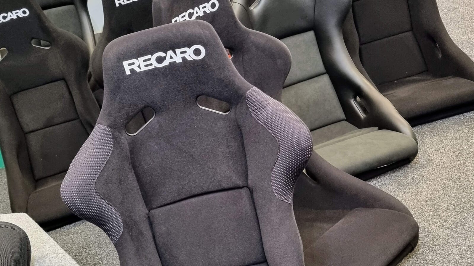 Rows of black Recaro bucket seats, including Pole Position seats, on the showroom floor