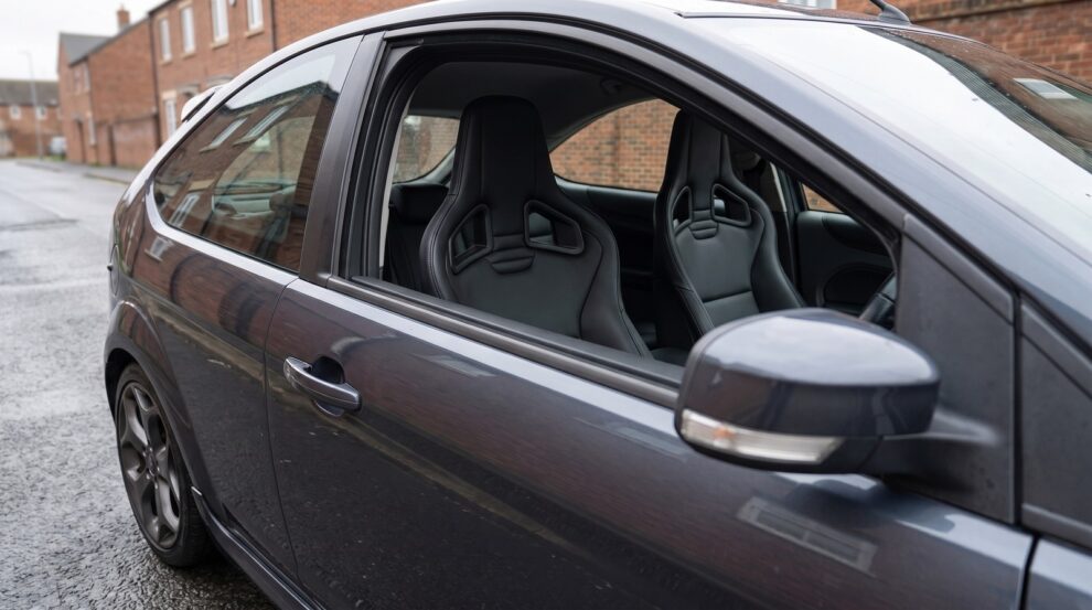 Recaro Sportster CS reclining seats fitted in a grey Ford Focus Mk2, seen through the closed driver door window