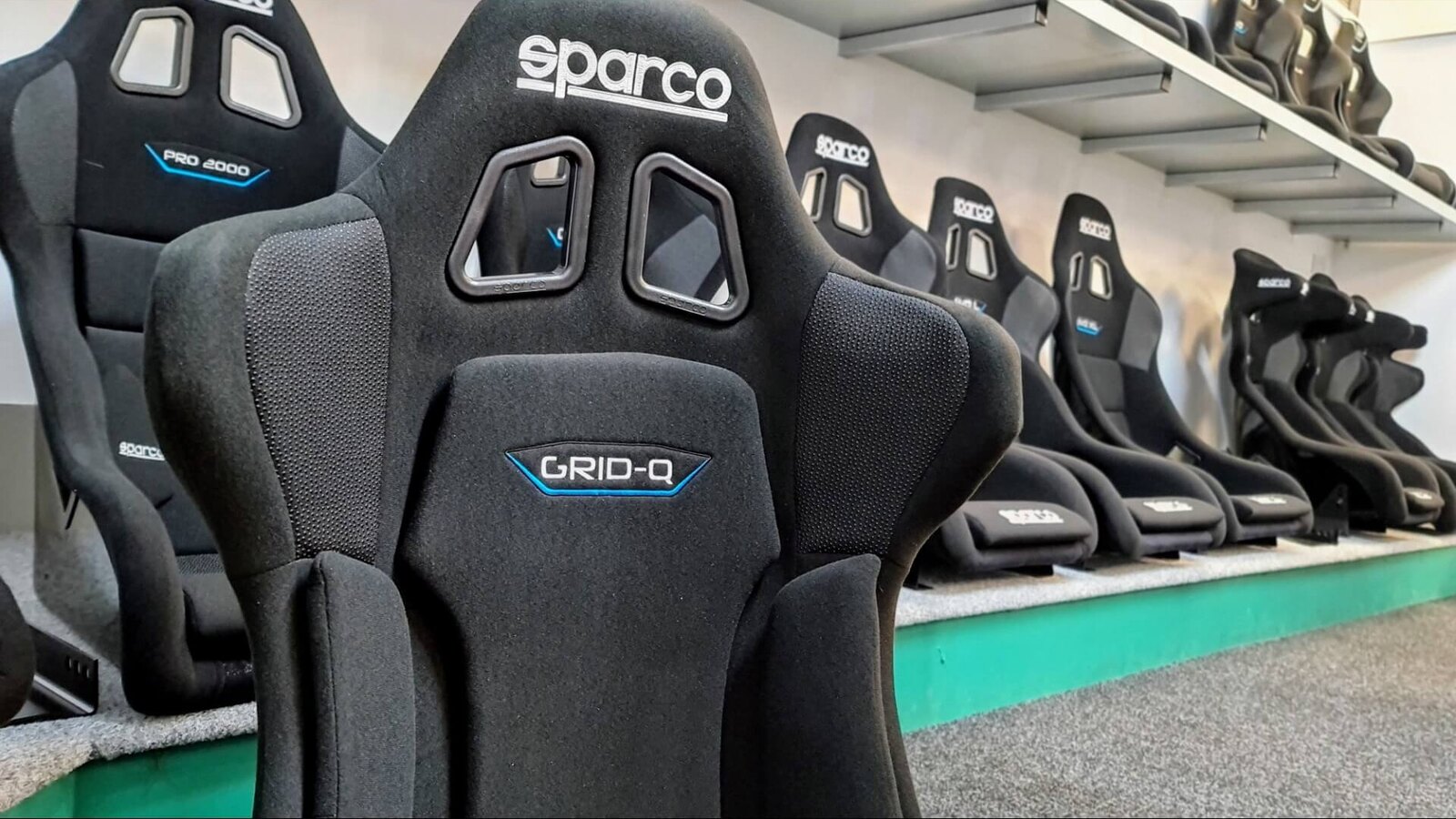 A black Sparco Grid Q bucket seat at the front of the Sparco seat display in the SportSeats4u showroom