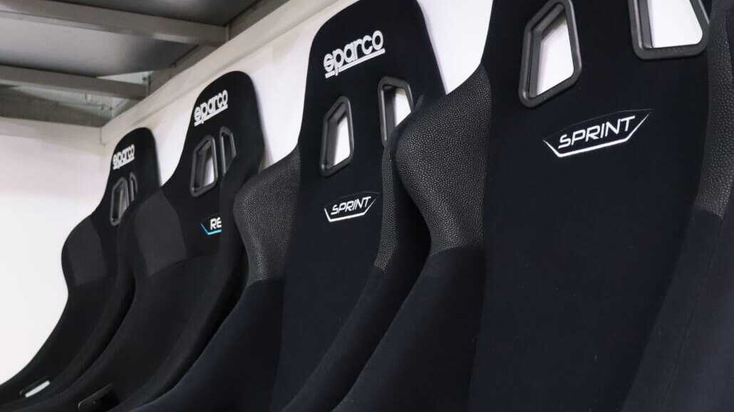 A row of black Sparco Sprint FIA bucket seats lined up on a showroom shelf