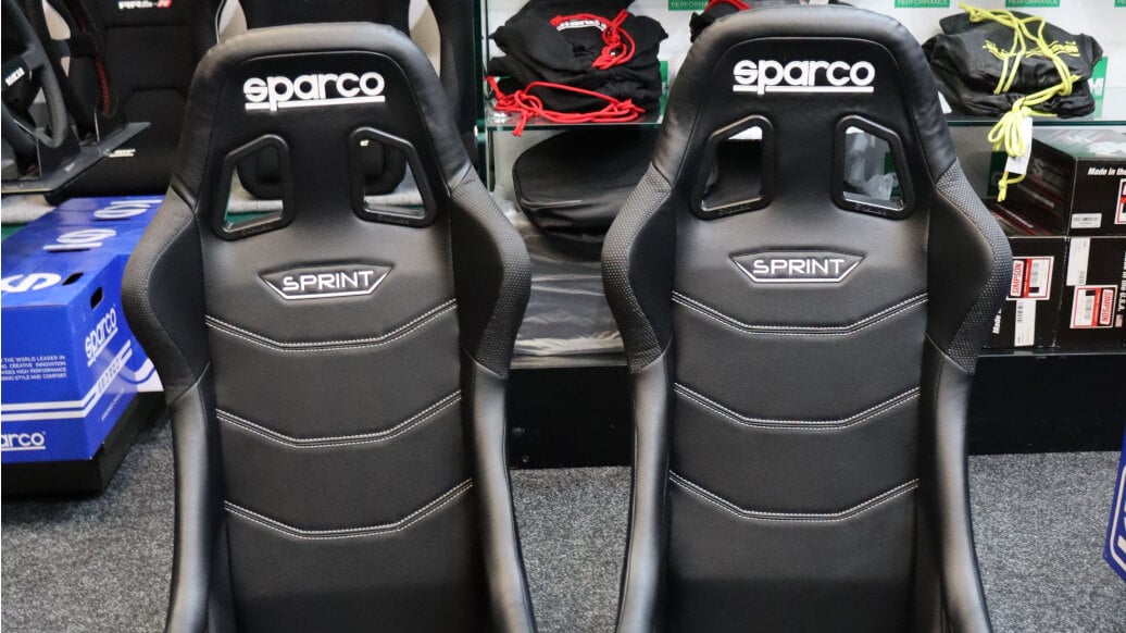 A pair of black vinyl Sparco Sprint Sky bucket seats with white stitching on the GSM Performance showroom floor