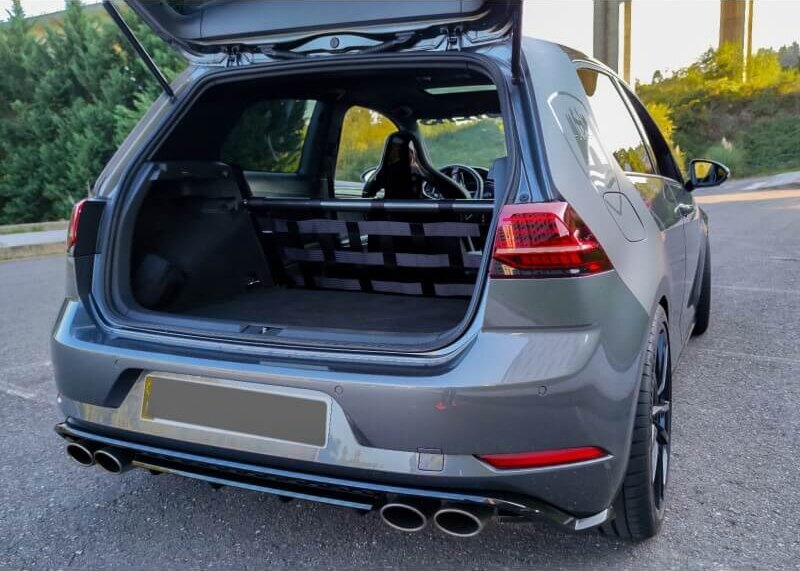 A grey VW Golf Mk7 with its boot open, showing a Stern Performance strut bar and black net where the rear seats were