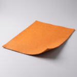 Swatch of tangerine orange soft grain automotive upholstery leather