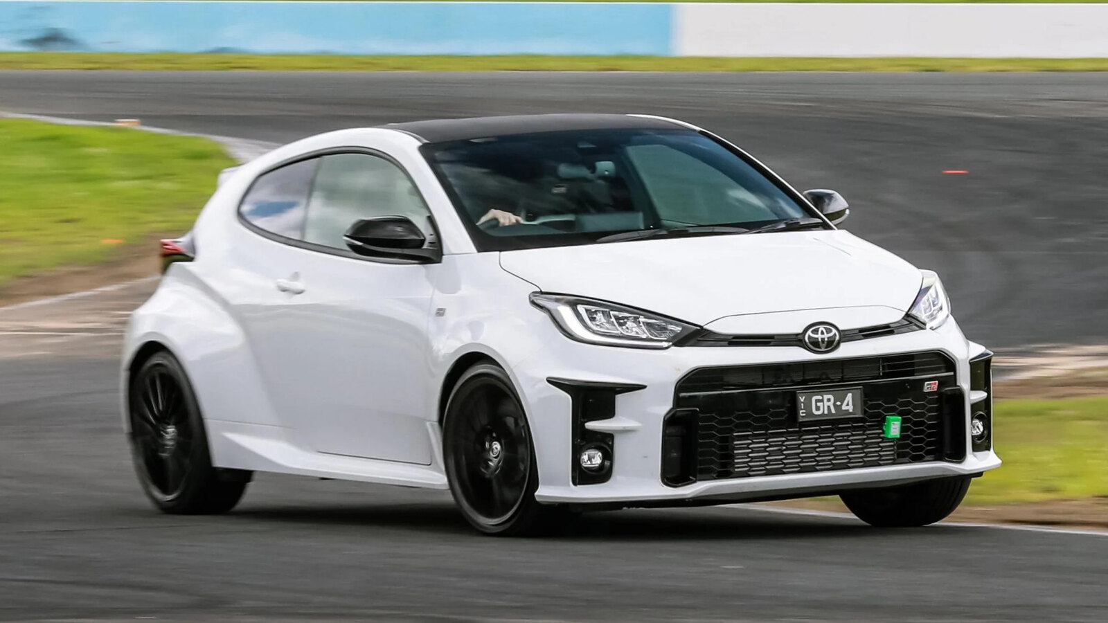 A white Toyota GR Yaris cornering on a race circuit