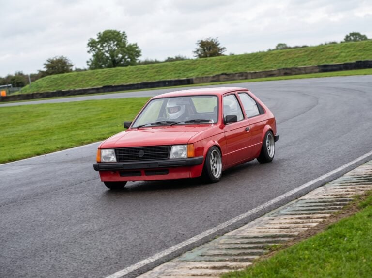 Red Vauxhall Astra Mk1 Kadett cornering on a British race circuit