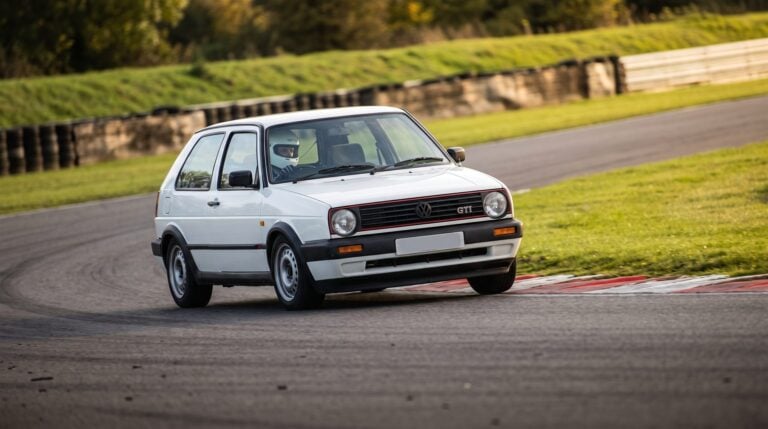 White Volkswagen Golf Mk2 hatchback cornering on a British circuit